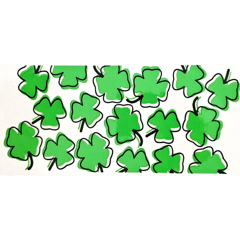 Green shamrock and clover vinyl decals with bold black outlines, scattered over a light surface
